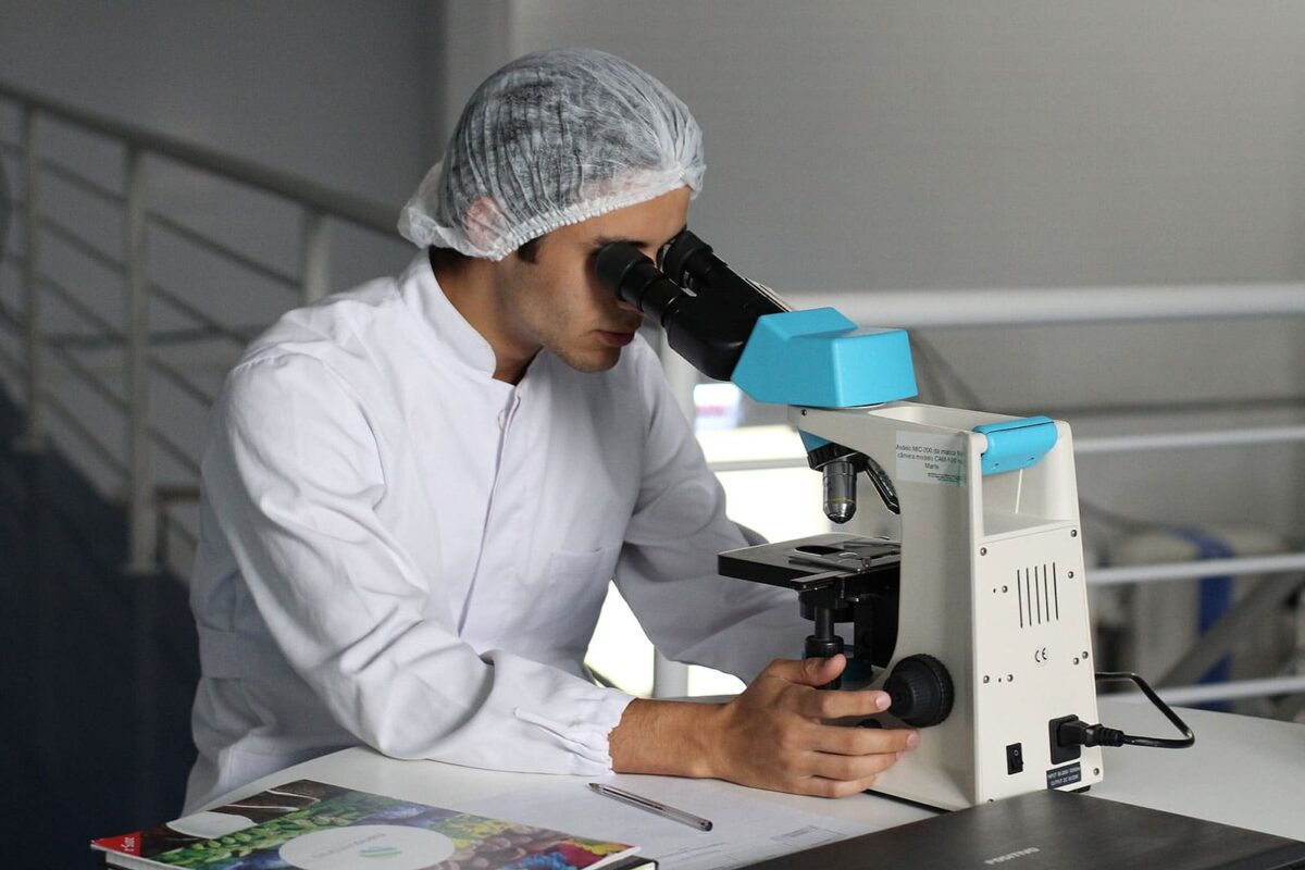 laboratory worker looking through microscope